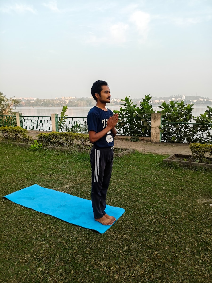 A man standing on a blue mat in a park